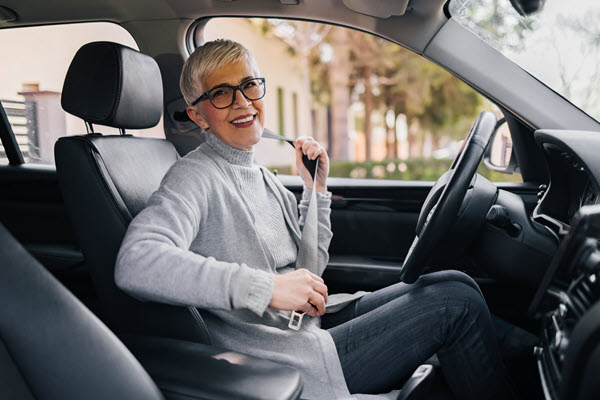 Smiling senior fastening seatbelt